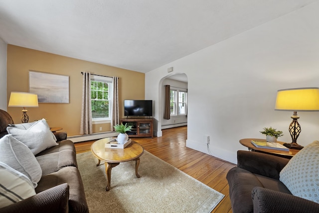 16 Ann Ave, Salem, NH 03079 - living area featuring a baseboard heating unit, arched walkways, and hardwood / wood-style flooring