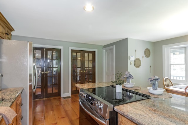 19 Cambridge Rd, Hampstead, NH 03841 - kitchen with french doors, appliances with stainless steel finishes, light wood-style floors, light stone counters, and brown cabinetry