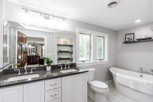 19 Cambridge Rd, Hampstead, NH 03841 - bathroom featuring double vanity, a freestanding tub, tile patterned floors, toilet, and baseboards
