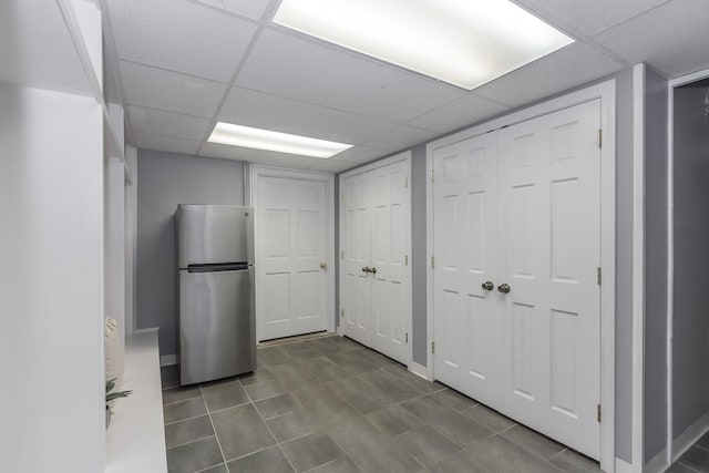 19 Cambridge Rd, Hampstead, NH 03841 - finished basement with freestanding refrigerator, a paneled ceiling, and dark tile patterned floors