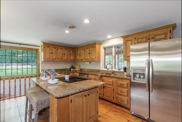 19 Cambridge Rd, Hampstead, NH 03841 - kitchen featuring stainless steel refrigerator with ice dispenser, a sink, stovetop, light wood finished floors, and light stone counters