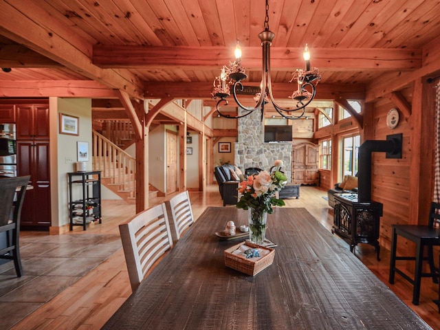 93 Rowell Hill Rd, New London, NH 03257 - dining area with a chandelier, stairway, a wood stove, wood finished floors, and wood ceiling with exposed beams