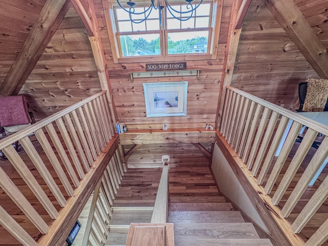 93 Rowell Hill Rd, New London, NH 03257 - staircase with wood walls, healthy amount of natural light, hardwood / wood-style flooring, beamed ceiling, and a chandelier