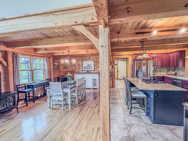 93 Rowell Hill Rd, New London, NH 03257 - dining space featuring wooden ceiling with exposed beams, a chandelier, wooden walls, and light wood finished floors