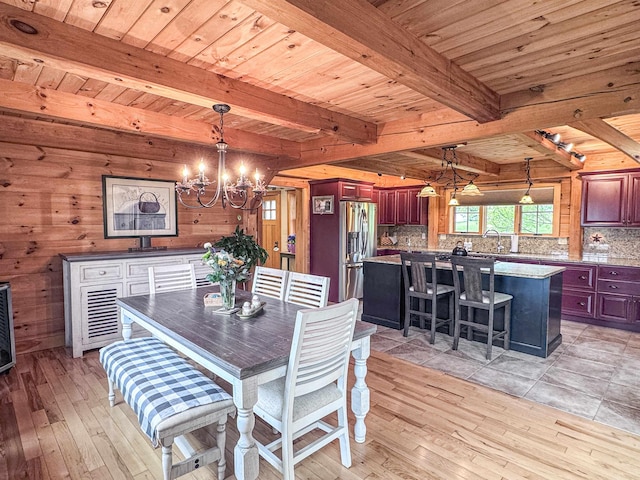 93 Rowell Hill Rd, New London, NH 03257 - dining area with a chandelier, wooden walls, light wood-style floors, and wooden ceiling with exposed beams