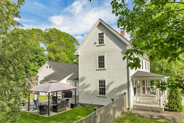 92 Mace Rd, Hampton, NH 03842 - back of property featuring a gazebo, a chimney, a patio area, and view of wooded area