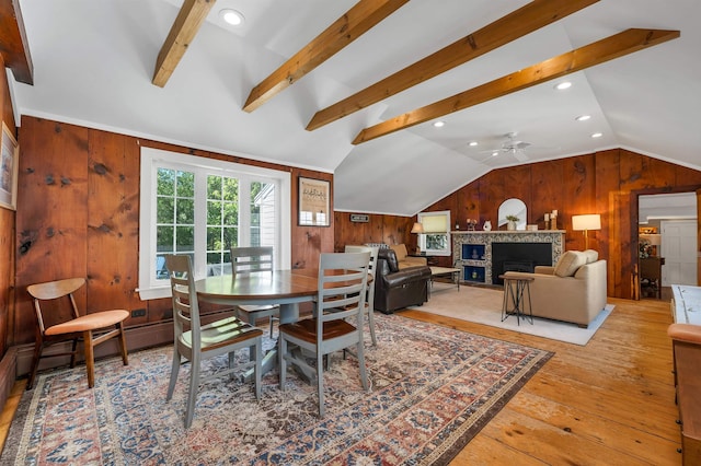 92 Mace Rd, Hampton, NH 03842 - dining room featuring lofted ceiling, wood walls, hardwood / wood-style flooring, a ceiling fan, and a fireplace