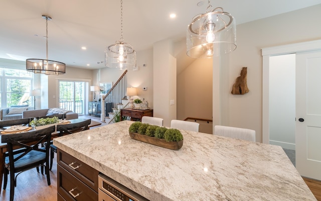 60 White Oaks Rd Unit 26, Laconia, NH 03246 - kitchen with light wood-type flooring, hanging light fixtures, open floor plan, light stone countertops, and recessed lighting