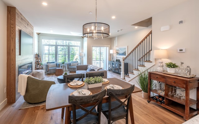 60 White Oaks Rd Unit 26, Laconia, NH 03246 - dining space with light wood-style floors, a large fireplace, stairway, a chandelier, and recessed lighting