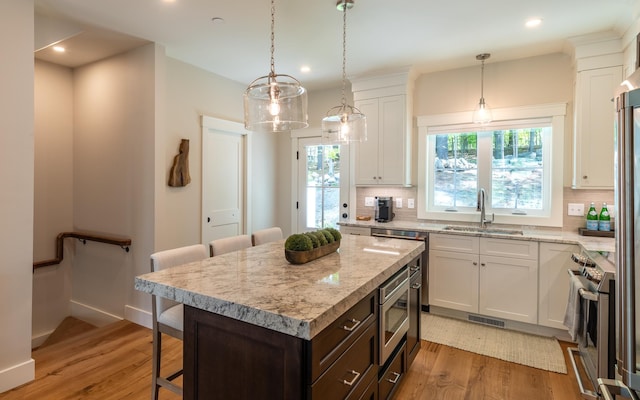 60 White Oaks Rd Unit 26, Laconia, NH 03246 - kitchen with a sink, appliances with stainless steel finishes, white cabinets, a breakfast bar area, and recessed lighting