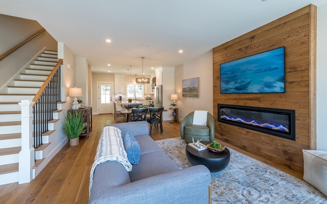 60 White Oaks Rd Unit 26, Laconia, NH 03246 - living room with stairs, light wood-type flooring, recessed lighting, a glass covered fireplace, and baseboards