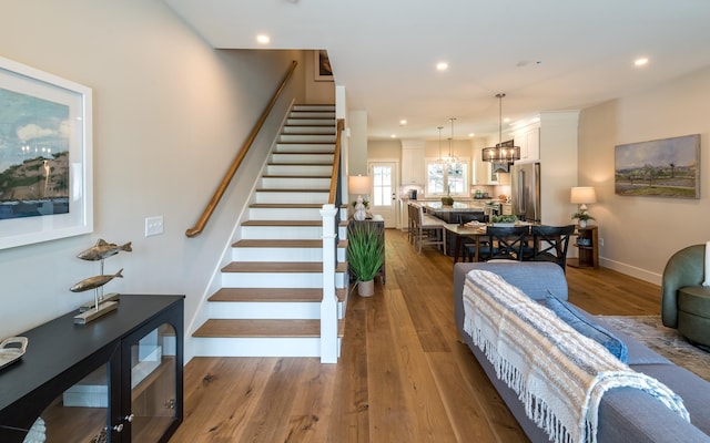 60 White Oaks Rd Unit 26, Laconia, NH 03246 - stairway featuring wood finished floors, a chandelier, recessed lighting, and baseboards