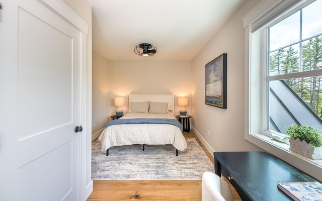 60 White Oaks Rd Unit 26, Laconia, NH 03246 - bedroom featuring multiple windows, baseboards, and wood finished floors