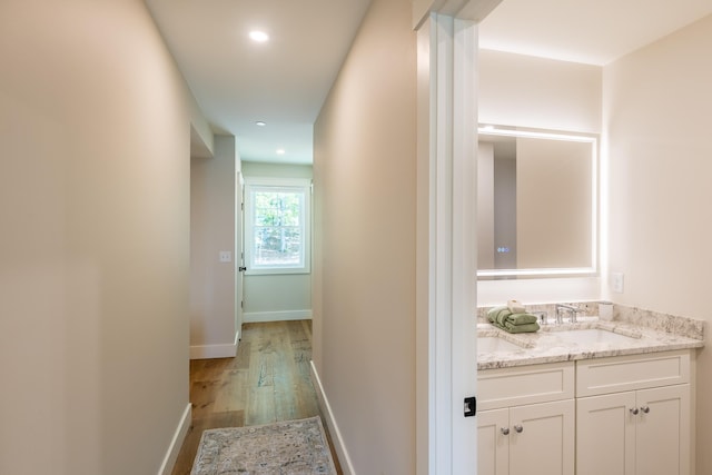 60 White Oaks Rd Unit 26, Laconia, NH 03246 - hallway with wood finished floors, a sink, recessed lighting, and baseboards