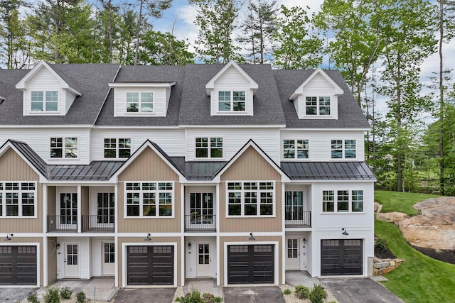 60 White Oaks Rd Unit 26, Laconia, NH 03246 - view of front of home featuring a standing seam roof, metal roof, driveway, a balcony, and an attached garage