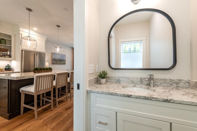 60 White Oaks Rd Unit 26, Laconia, NH 03246 - bathroom with wood finished floors, vanity, and decorative backsplash