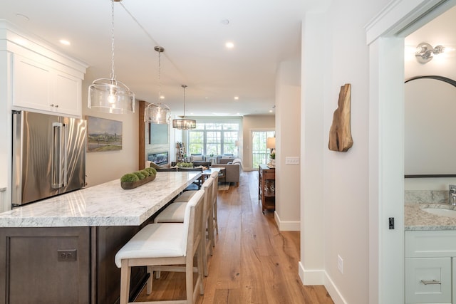 60 White Oaks Rd Unit 26, Laconia, NH 03246 - kitchen featuring freestanding refrigerator, light wood finished floors, white cabinetry, a sink, and recessed lighting