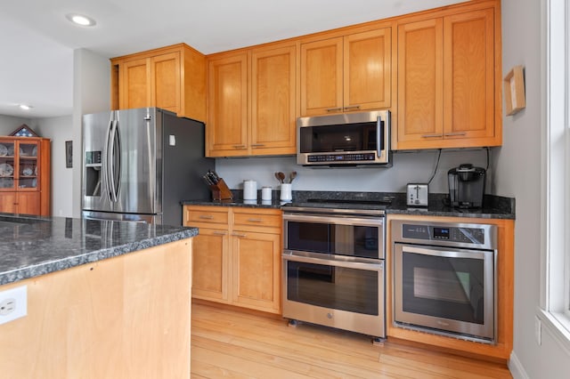 345 Williams Rd, Littleton, NH 03561 - kitchen with appliances with stainless steel finishes, light wood-type flooring, recessed lighting, dark stone counters, and brown cabinets