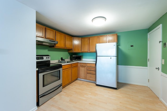 101 E Broadway Rd Unit 1, Derry, NH 03038 - kitchen featuring stainless steel appliances, under cabinet range hood, a sink, and light wood finished floors