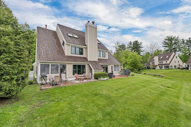 51 Cardinal Dr Unit B, Laconia, NH 03246 - back of house with a patio area, a lawn, a chimney, and roof with shingles