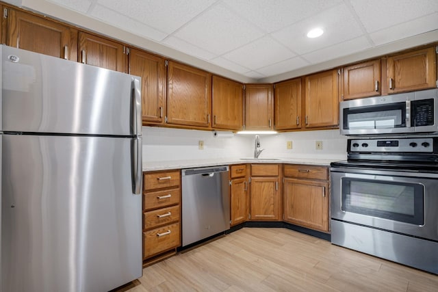 137 E Mountain Rd Unit 2E1, Killington, VT 05751 - kitchen with stainless steel appliances, a sink, light countertops, brown cabinets, and a paneled ceiling