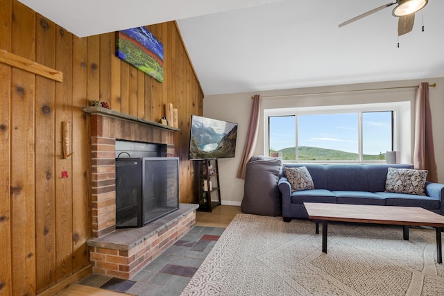 137 E Mountain Rd Unit 2E1, Killington, VT 05751 - living area with wooden walls, lofted ceiling, a brick fireplace, ceiling fan, and baseboards
