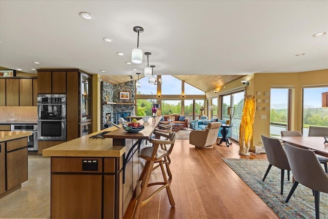 83 Dewey Farm Rd, Stowe, VT 05672 - kitchen featuring open floor plan, lofted ceiling, stainless steel double oven, pendant lighting, and recessed lighting