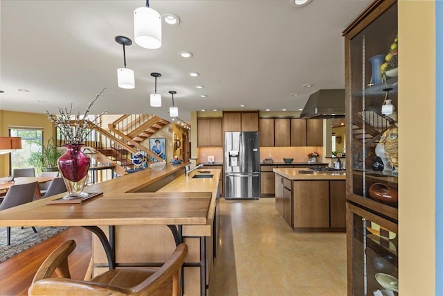 83 Dewey Farm Rd, Stowe, VT 05672 - kitchen with stainless steel fridge with ice dispenser, finished concrete floors, a sink, recessed lighting, and a kitchen island