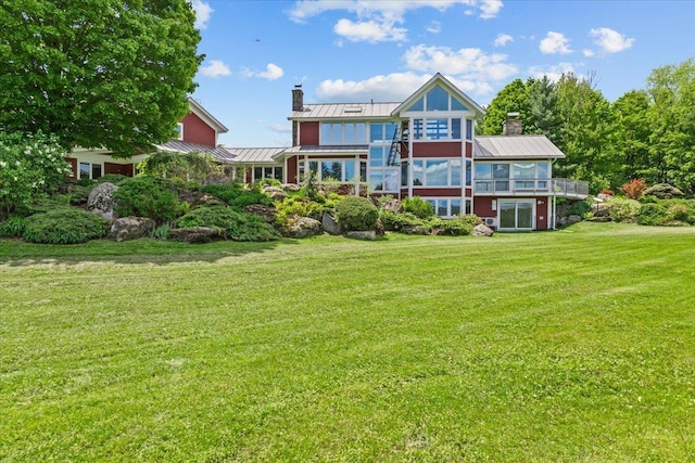 83 Dewey Farm Rd, Stowe, VT 05672 - back of property featuring a standing seam roof, a chimney, a lawn, and metal roof