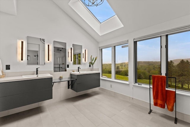 83 Dewey Farm Rd, Stowe, VT 05672 - full bathroom featuring a skylight, two vanities, high vaulted ceiling, a shower, and baseboards