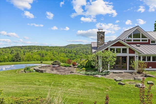 83 Dewey Farm Rd, Stowe, VT 05672 - view of green lawn with a wooded view, a patio area, and a water view
