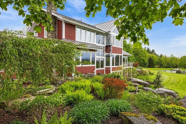 83 Dewey Farm Rd, Stowe, VT 05672 - back of property with a standing seam roof, metal roof, a sunroom, a water view, and a chimney