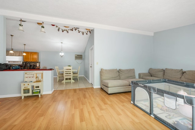 4 Johns Dr Unit A, Hooksett, NH 03106 - living area featuring a wall mounted air conditioner, light wood-style floors, baseboards, and vaulted ceiling