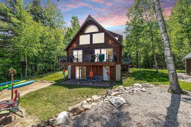 72 Auclair Rd, Middleton, NH 03887 - back of property at dusk featuring log siding, a deck, a yard, and a patio