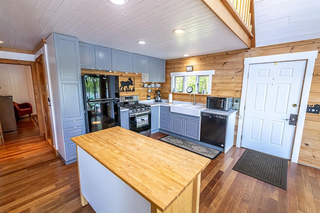 72 Auclair Rd, Middleton, NH 03887 - kitchen with black appliances, a sink, butcher block counters, dark wood-type flooring, and wood walls