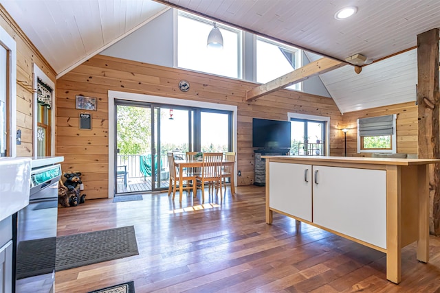 72 Auclair Rd, Middleton, NH 03887 - kitchen featuring lofted ceiling, wood walls, hardwood / wood-style floors, white cabinets, and open floor plan