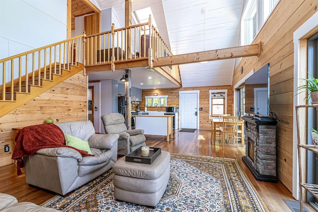 72 Auclair Rd, Middleton, NH 03887 - living area featuring wood walls, wood finished floors, stairs, and high vaulted ceiling