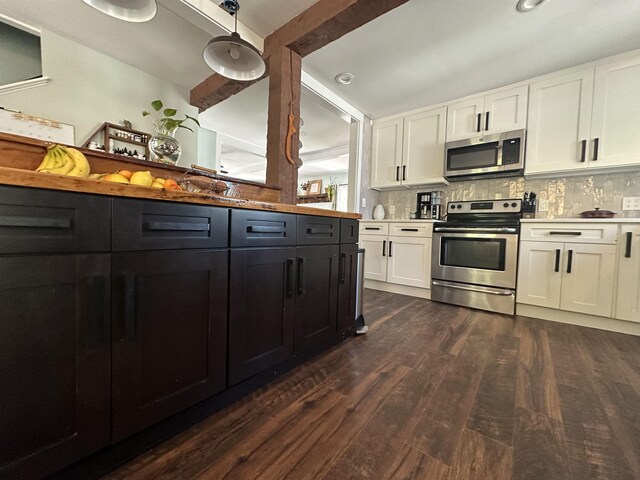 8 Main St, Bennington, NH 03442 - kitchen with appliances with stainless steel finishes, white cabinets, dark wood-type flooring, light countertops, and tasteful backsplash
