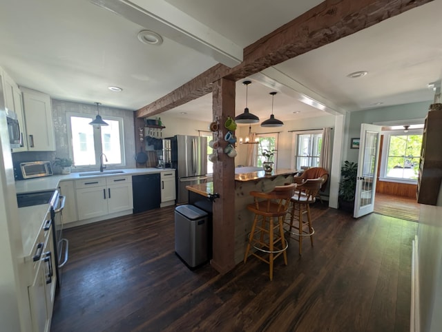 8 Main St, Bennington, NH 03442 - kitchen featuring a sink, appliances with stainless steel finishes, white cabinetry, dark wood finished floors, and a kitchen bar