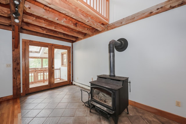278 N Rd, Deerfield, NH 03037 - unfurnished living room featuring french doors, baseboards, baseboard heating, a wood stove, and beam ceiling