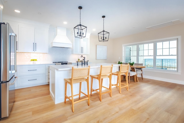465 Ocean Blvd Unit 201, Hampton, NH 03842 - kitchen with custom exhaust hood, freestanding refrigerator, light wood-type flooring, recessed lighting, and tasteful backsplash