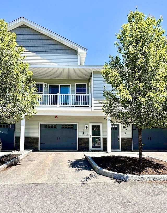 17 Callaway Dr Unit 4, Concord, NH 03301 - view of front of property featuring stone siding, a garage, driveway, and a balcony