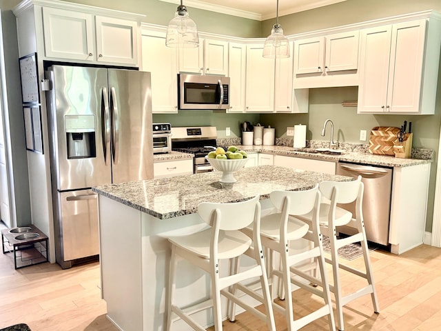 17 Callaway Dr Unit 4, Concord, NH 03301 - kitchen with stainless steel appliances, a sink, ornamental molding, light wood-type flooring, and a kitchen island