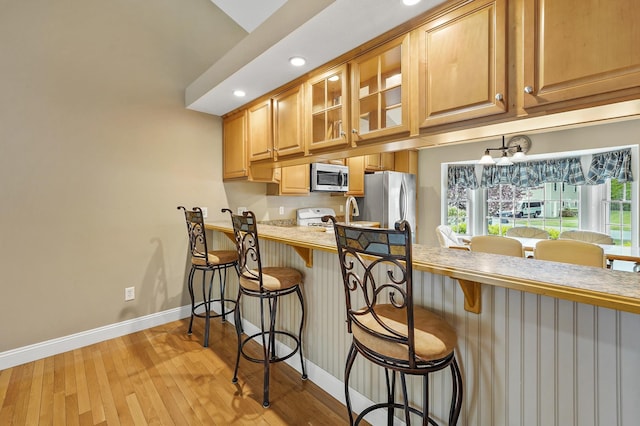 27 Autumn Ln, Hampstead, NH 03826 - kitchen with stainless steel appliances, baseboards, light wood-type flooring, glass insert cabinets, and recessed lighting