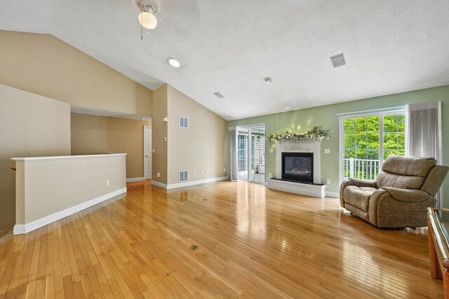 27 Autumn Ln, Hampstead, NH 03826 - living room featuring light wood-type flooring, baseboards, a glass covered fireplace, high vaulted ceiling, and ceiling fan