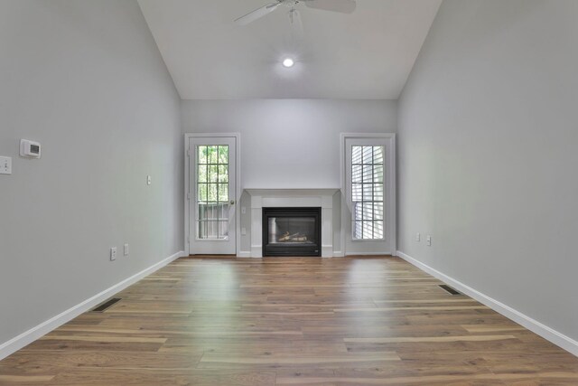 1465 Hooksett Rd Unit 403, Hooksett, NH 03106 - unfurnished living room featuring a glass covered fireplace, ceiling fan, wood finished floors, baseboards, and high vaulted ceiling