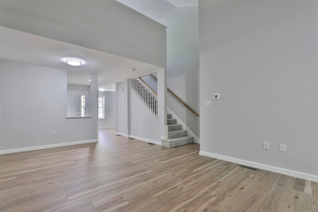 1465 Hooksett Rd Unit 403, Hooksett, NH 03106 - unfurnished living room with stairway, light wood-type flooring, and baseboards