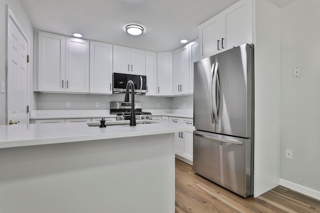 1465 Hooksett Rd Unit 403, Hooksett, NH 03106 - kitchen featuring stainless steel appliances, light countertops, white cabinets, recessed lighting, and wood finished floors