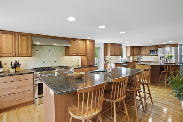 245-247 Danville Rd, Fremont, NH 03044 - kitchen with wall chimney exhaust hood, appliances with stainless steel finishes, a center island with sink, a sink, and recessed lighting