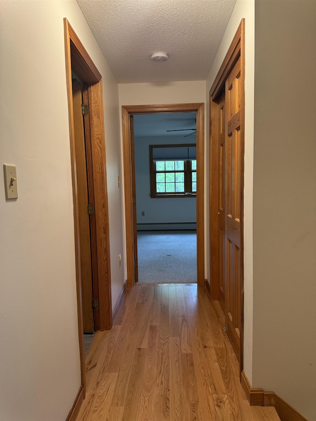 52 Jericho Rd, Grantham, NH 03753 - hall with light wood-style floors, a textured ceiling, baseboards, and a baseboard heating unit